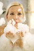 Woman blowing the foam in the bath