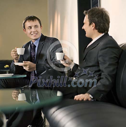 Two businessmen talking and having a coffee