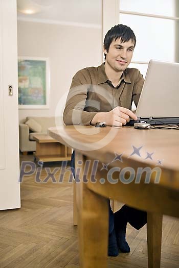 Man sitting on the table, working with laptop