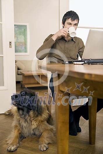 Man sitting on the table, dog on the floor