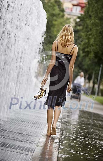 Woman in the park walking on wet ground