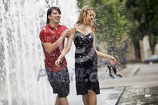 Couple having fun in the fountain Couple having fun in the fountain