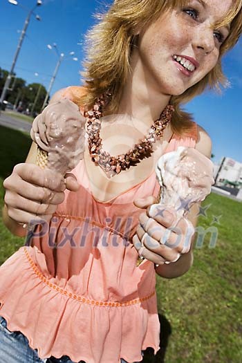 Woman standing with two icecreams that are melting