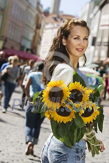Woman on the busy summer street with sunflowers