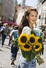 Woman on the busy summer street with sunflowers