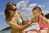 Woman putting suncream on her daughter