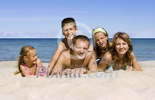 Family lying on the sand 