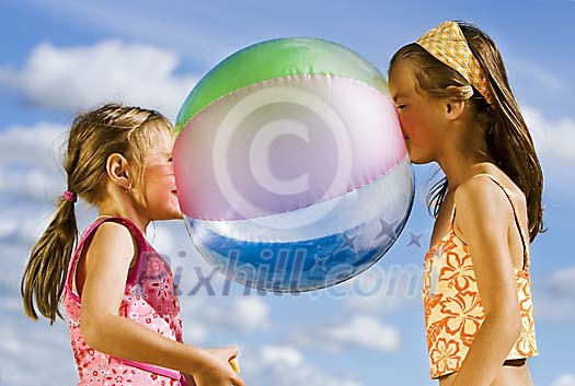 Two girls having fun with the beach ball