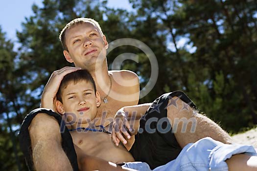 Man with his son chilling on the beach