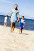 Woman and child walking on sand