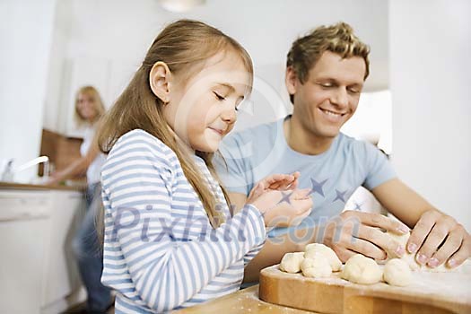 Man and girl rolling the buns Man and girl rolling the buns