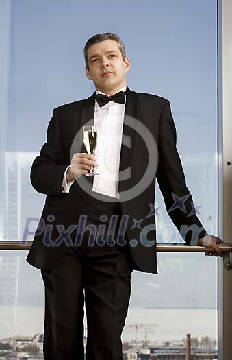 Man in tuxedo standing by the window