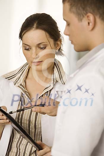 Male doctor giving advice to a female nurse