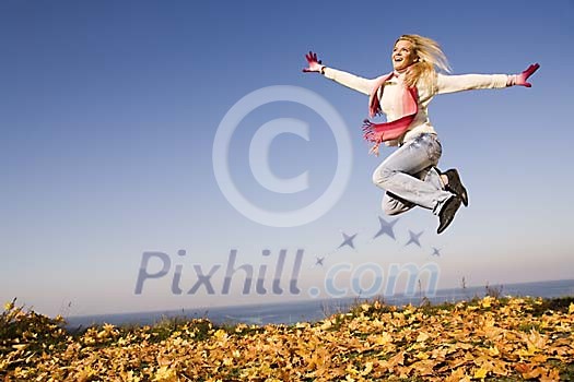 Woman jumping on the autumn leaves