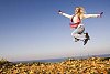 Woman jumping on the autumn leaves