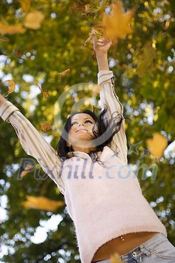 Woman throwing leaves in the air Woman throwing leaves in the air