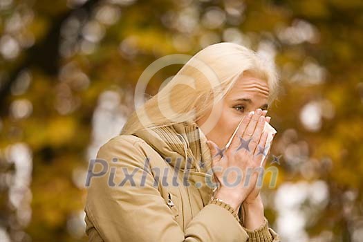 Woman sneezing in the park
