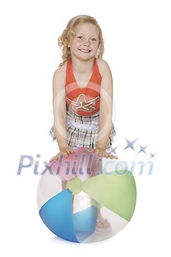 Girl smiling and standing behind the beachball