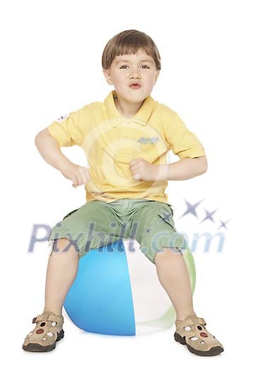 Boy sitting on the beachball