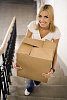 Woman carrying a box up the stairs