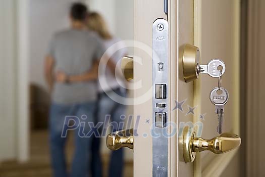 Couple standing behind a open door