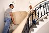 Man and woman carrying a sofa up the stairs