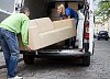 Man and woman lifting the sofa out of the van