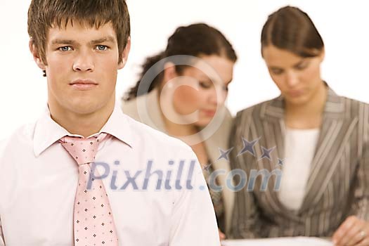 Businessman up front and two women at the back Businessman up front and two women at the back