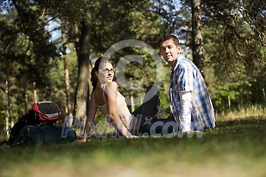 Couple sitting on the ground in the woods
