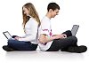 Couple of teenagers sitting on the floor with laptops