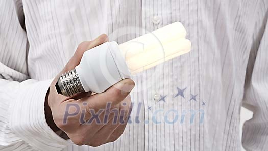 Male hand holding a lighted light bulb