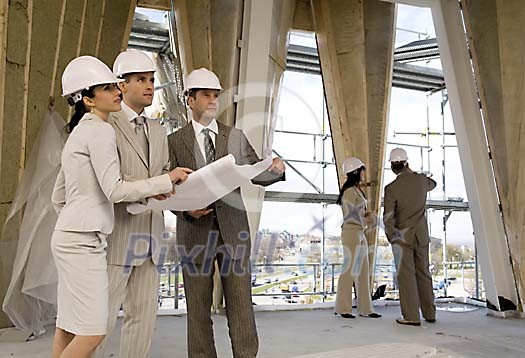 Men and women at the constuction site inspecting