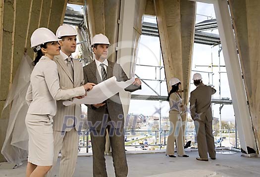 Men and women at the constuction site inspecting Men and women at the constuction site inspecting