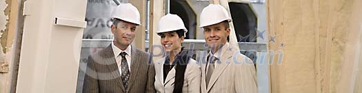 Men and a women smiling at the construction site Men and a women smiling at the construction site
