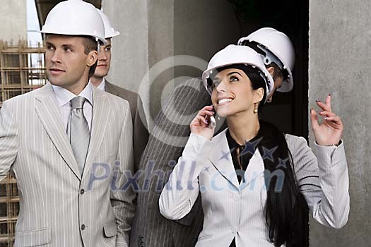 Men and a woman at the construction site Men and a woman at the construction site