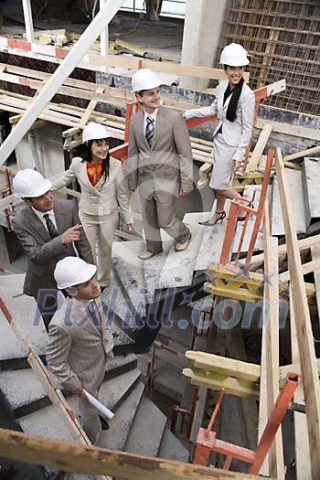Group of people going down of the stairs at the construction site Group of people going down of the stairs at the construction site