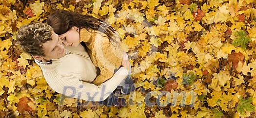 Couple standing surrounded by autumn leaves