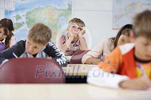 Schoolboy daydreaming in the classroom