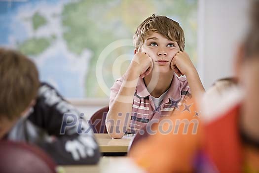 Schoolboy looking bored in the classroom
