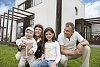 Family posing in front of a house