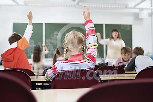 Students hands up in the classroom