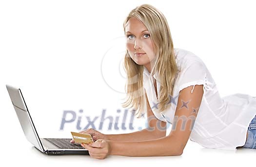 Woman with a laptop on the floor and a credit card in her hand