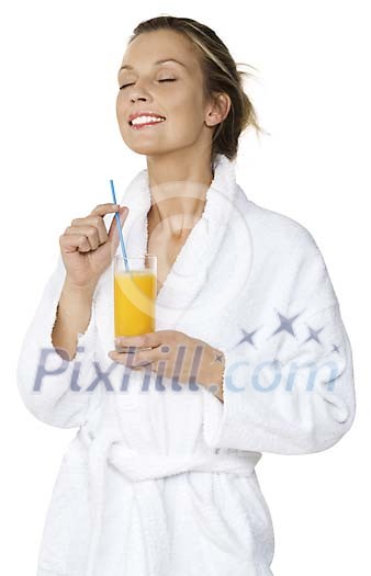 Woman in bathrobe enjoying a glass of juice