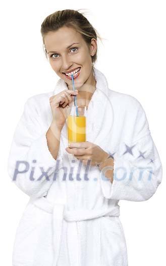 Woman in bathrobe sipping juice