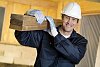 Male carpenter carrying wood at worksite