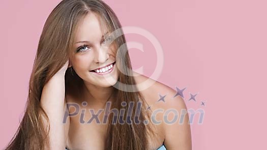 Woman smiling on a pink background