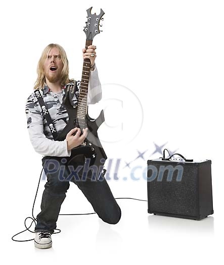 Isolated male rockstar with a electric guitar