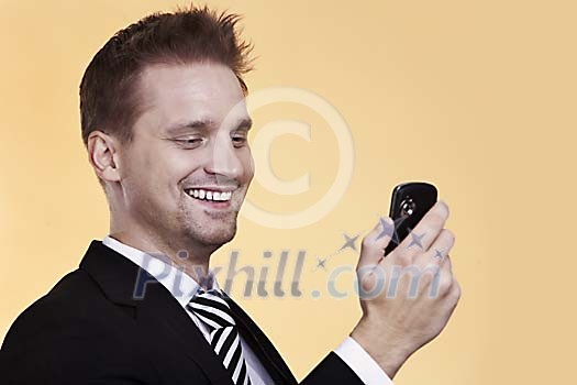 Businessman smiling while looking at his phone