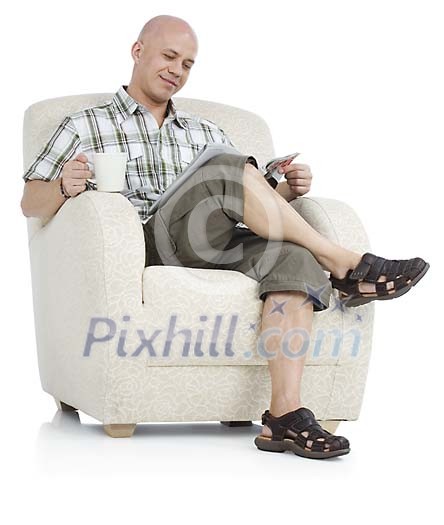 Isolated man sitting on a armchair, reading