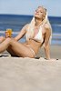 Woman in bikinis sitting on the sand, enjoying sun